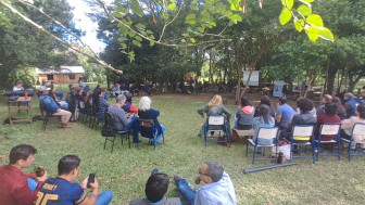 Pessoas sentadas em círculo em meio a uma mata