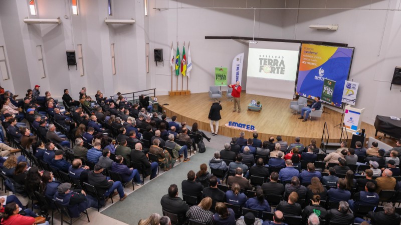 Imagem aberta com plateia cheia no salão da Unijui