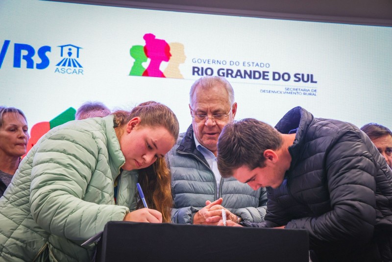 Jovens assinam contratos do Agrofamilia enquanto o secretário Vilson Covatti acompanha