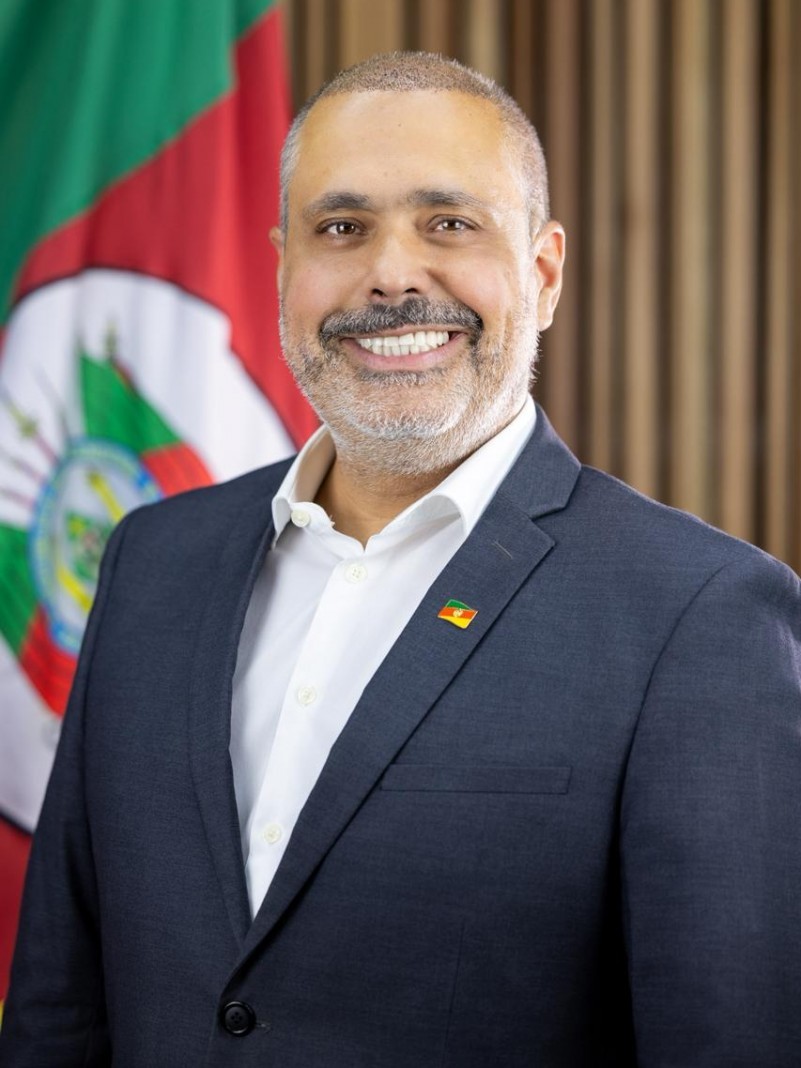 Homem de perfil posa sorrindo para a foto.